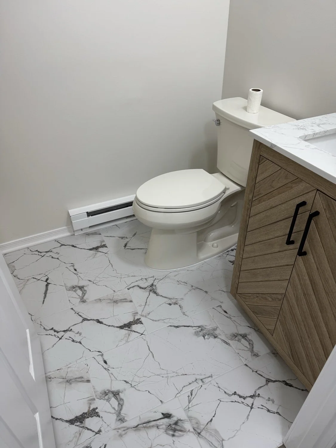 A wood-tone vanity paired with marble-look floor tile.